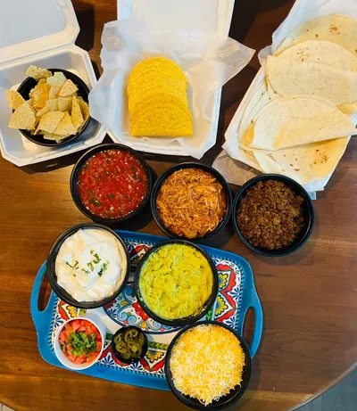 Taco bar spread — tortillas, shells, salsas, guacamole and toppings