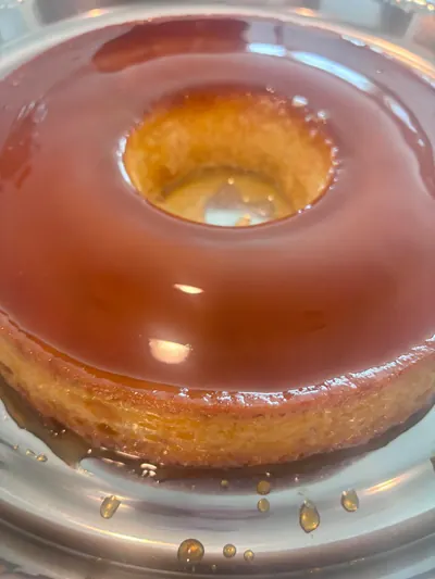 Whole caramel flan in its glass dish