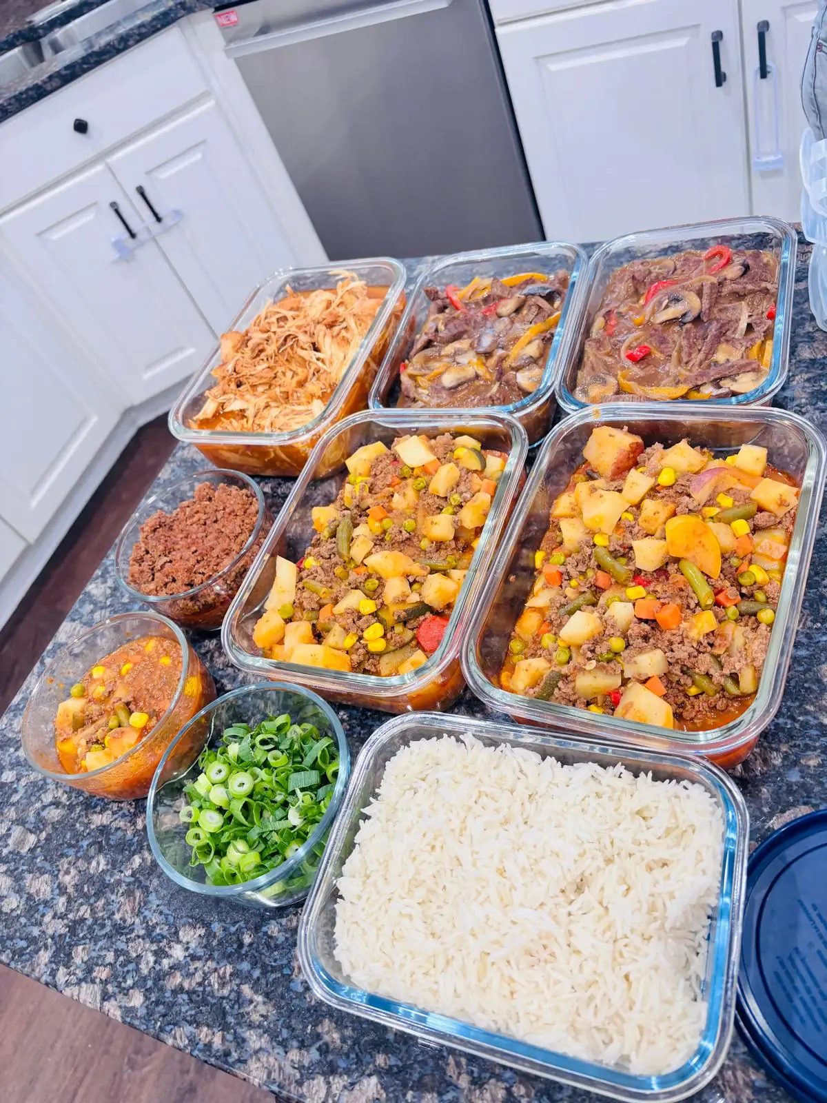 Catering trays of chef-prepared mains, sides and rice laid out for a party