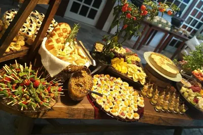 Rustic buffet of skewers, filled pastries and canapés under warm light