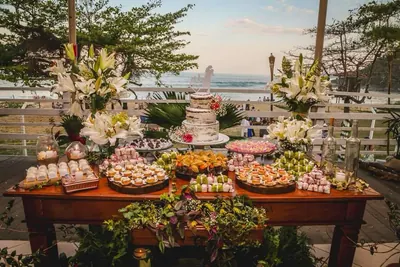 Seaside dessert table with a naked wedding cake, white lilies and trays of sweets