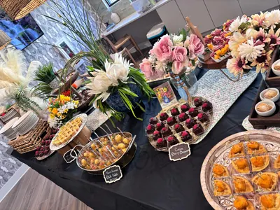 Flower-dressed reception table of chocolate-dipped strawberries, canapés and desserts