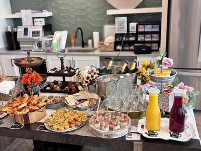 Brunch spread of tiered pastries, canapés and carafes of juice beside a champagne bucket