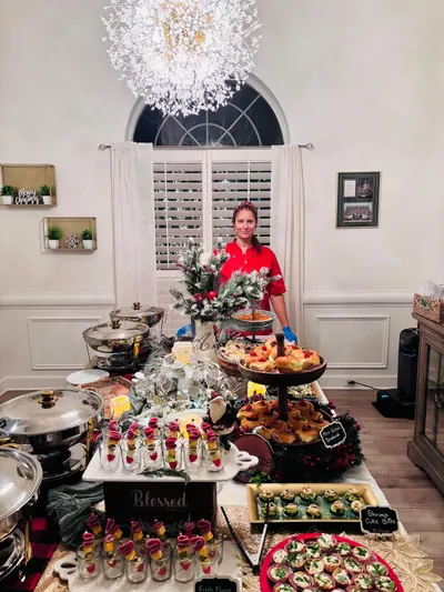 Chef behind a festive buffet of shooters, sliders and chafing dishes