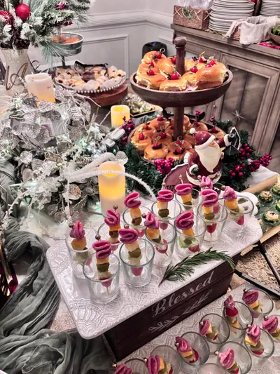 Cups of skewered bites on a 'Blessed' stand, with tiered sliders and candles